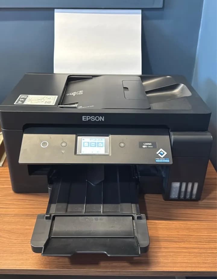 Epson EcoTank L14150 vista frontal imprimindo em formato A3+ com tanques de tinta visíveis